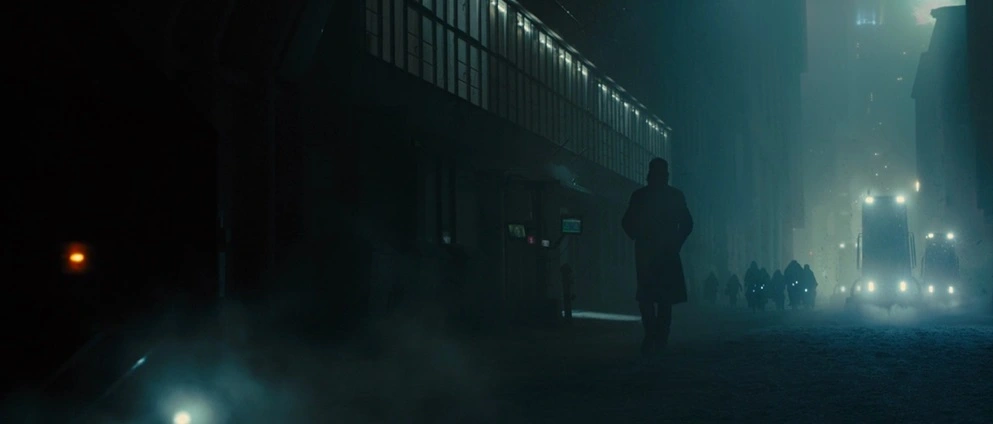 A man is walking in a dark street. From the movie 'Blade Runner: 2049' by Denis Villeneuve.